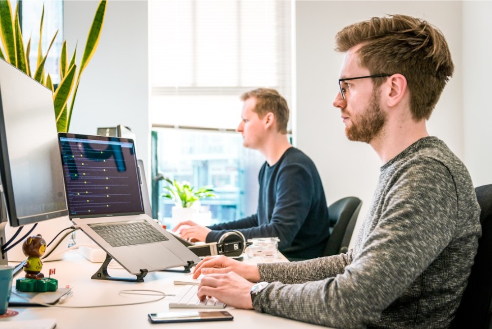 Team members using their computers to enhance data-driven decision making with AI orchestration platforms